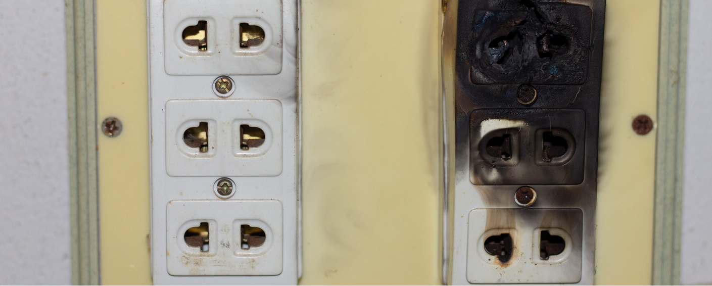 Two electrical outlet panels side by side; the left panel is clean, while the right is blackened and burnt—almost as if a single ant had caused chaos, highlighting the dramatic effects of fire damage.